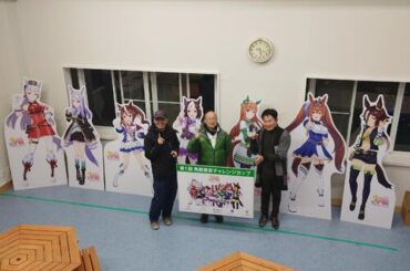 「ウマ娘　プリティーダービー」のパネルと角居元調教師（中央）左は元五輪選手の広田龍馬さん、右はホースツリー古田雅士代表（乗馬プラザ・ホースツリー提供、22年12月撮影）