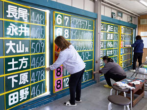 姫路競馬場のパドックボードに手書きで記入する女性スタッフ