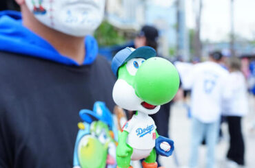ドジャース対ガーディアンズ　配られたドジャース山本のヨッシーボブルヘッドを手にするファン（撮影・垰建太）
