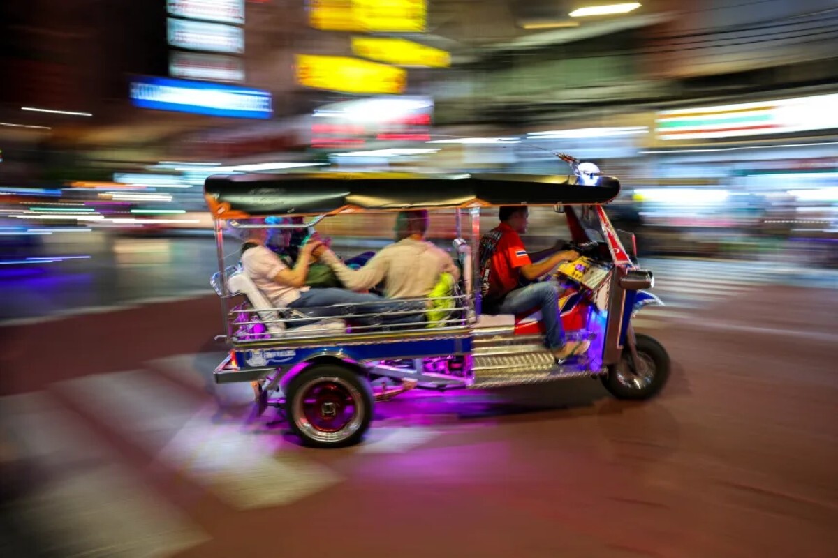 バンコクの中華街で3輪タクシー「トゥクトゥク」に乗る観光客たち/Athit Perawongmetha/Reuters