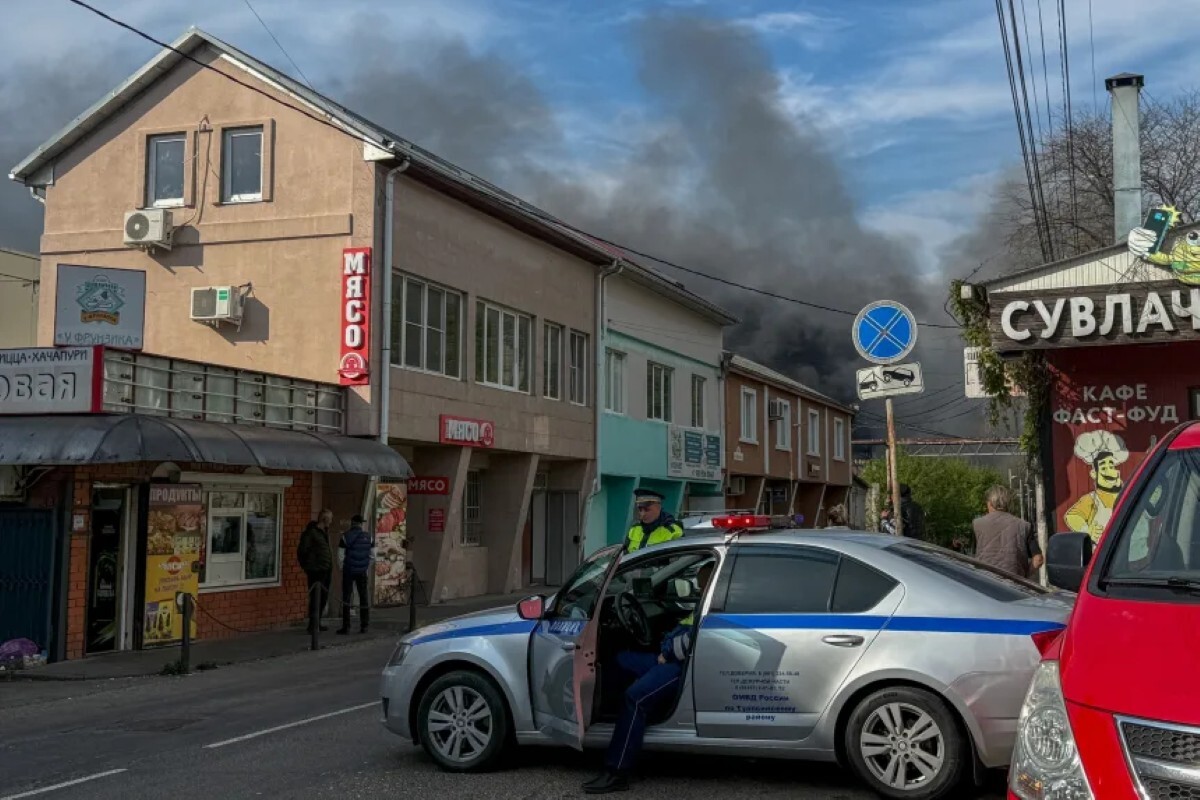 トゥアプセにある石油精製所がドローン攻撃を受け、煙が立ち上る中、ロシア警察官が現場周辺の安全を確保する様子＝4月29日/Stringer/AFP/Getty Images