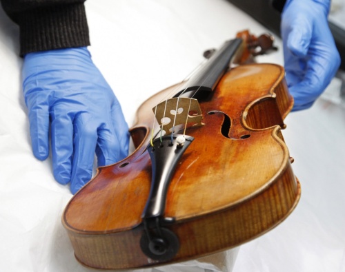 パリの音楽博物館内の修復研究所で、美しい音色で有名な名器「ストラディバリウス」をフランスの化学者が調べている。新たな研究により、表板に使われた木材の産地が判明した。（PATRICK KOVARIK/AFP, GETTY IMAGES）