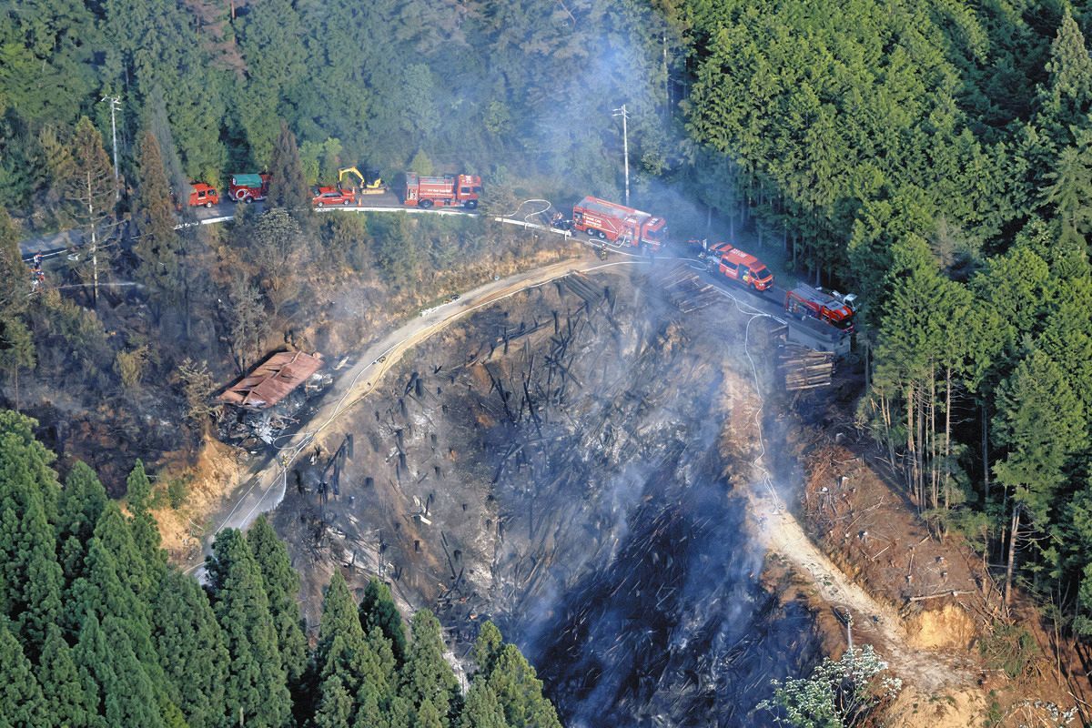 消火活動が行われる山林火災の現場＝13日午後5時17分、岐阜県恵那市で、本社ヘリ「まなづる」から