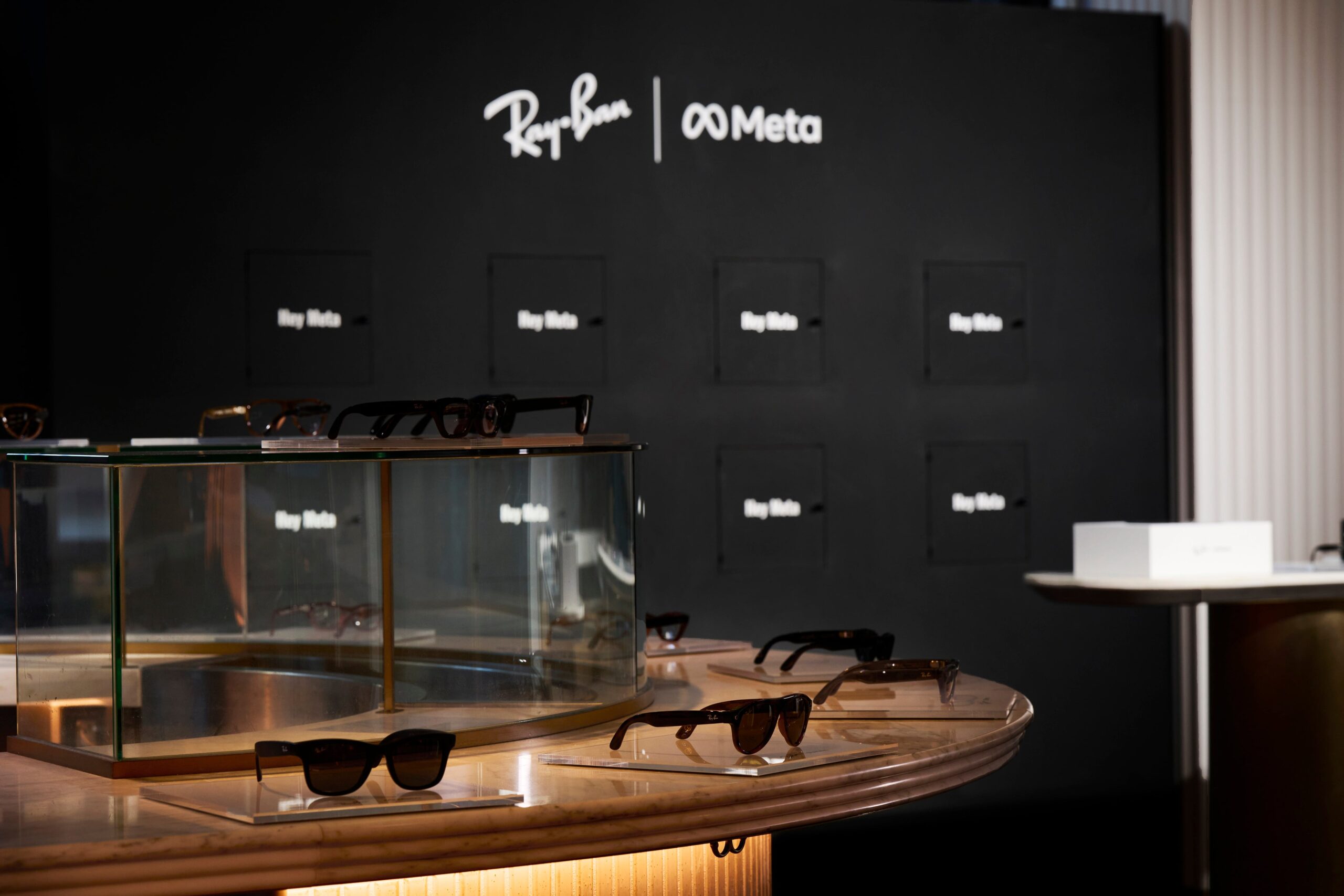 Ray-Ban Meta (Gen 3)発売記念イベントの展示。Ray-BanとMetaのロゴの前にRay-Ban Metaのサングラスが並ぶ